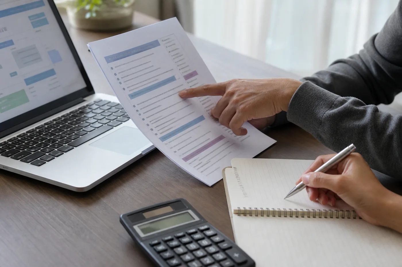Pessoa comparando documentos e condições oficiais de investimentos